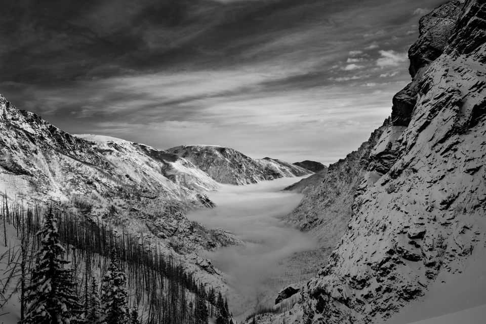 Above the Fog, Beartooth Mountains, Montana. Fog holds in East Rosebud Canyon through the morning as we climb on skis high above the valley floor.