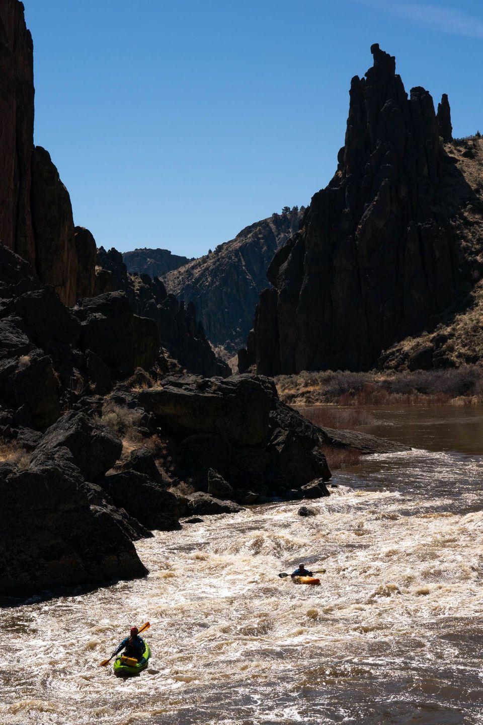 Desert Silhouettes. Backlit spires and kayakers on an afternoon on the Middle Owyhee.