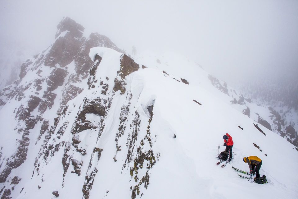 Prepping at the Edge. Two skiers prep for a steep descent.