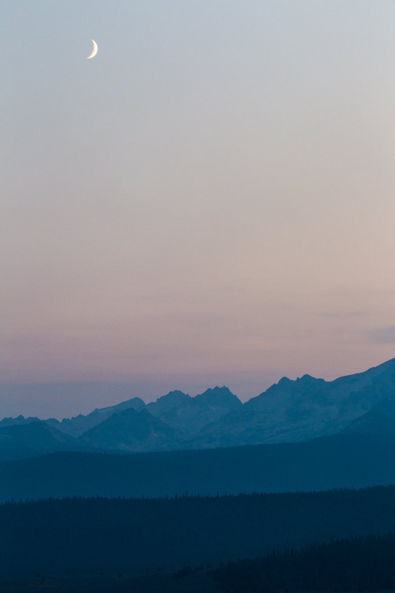 Sawtooth Range at Dusk, Idaho. A sliver of moon hangs above the Sawtooth Mountains.